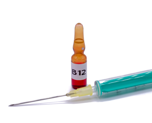 B12 vial with syringe isolated on white background